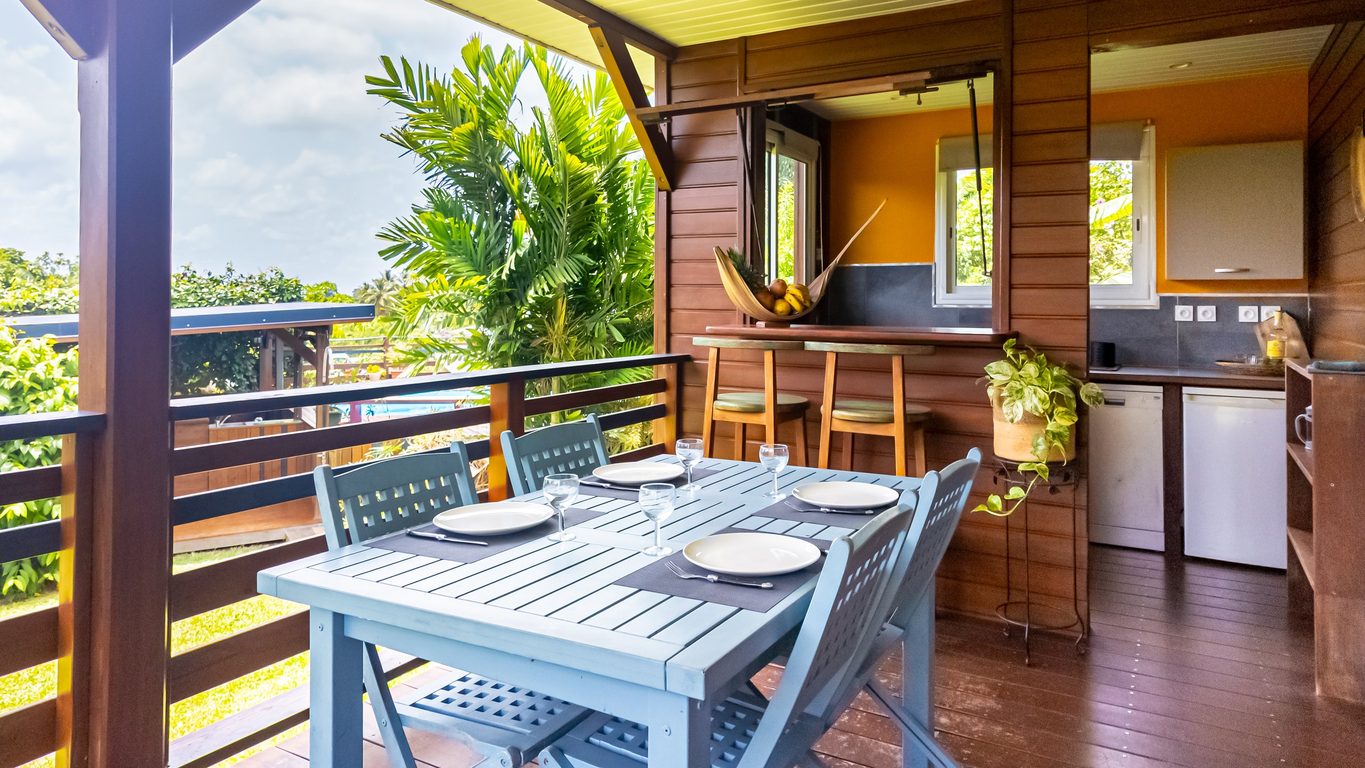 Terrasse couverte avec table dressée et cuisine extérieure, bungalow Ti Briz Guadeloupe