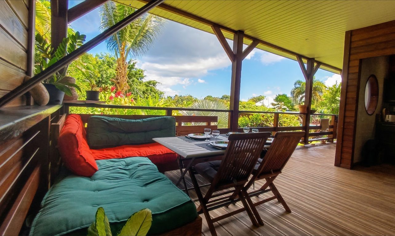 Terrasse panoramique avec salon coloré et vue jardin tropical, bungalow Souf Van Guadeloupe
